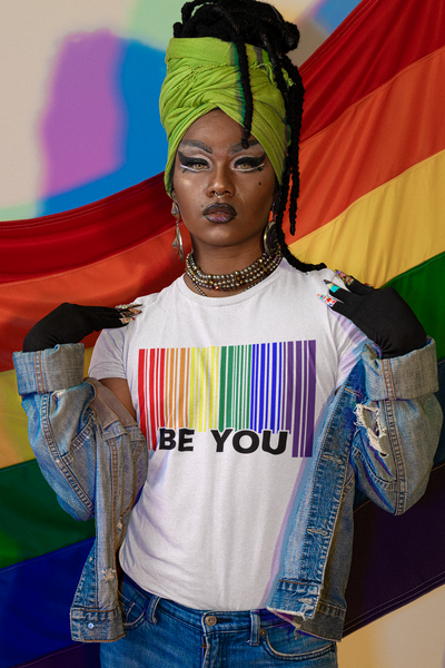Be You Pride color barcode T-Shirt on a person posing against a pride flag